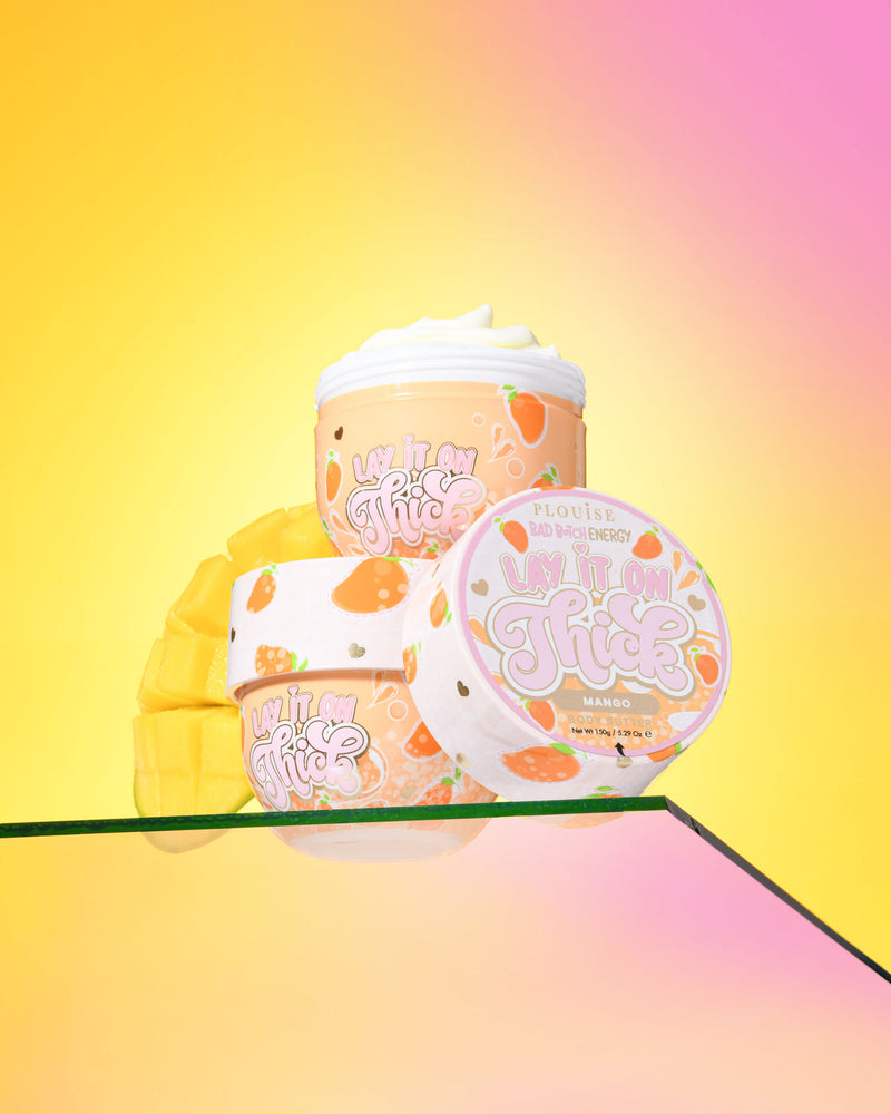 Tre behållare med P. Louise 'Lift It On Thick' mango body butter på en gradient gul och rosa bakgrund