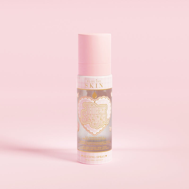 En rosa sprayflaska märkt 'P.Louise SKIN' med en skildring av ett hjärta och några blommiga element, innehållande en återfuktande inställningsspray.