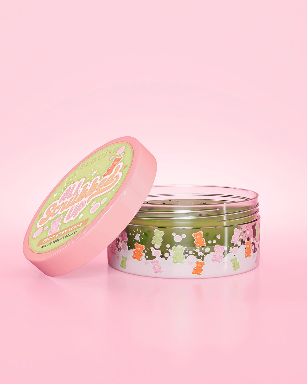 Öppen burk med P. Louise All Scrubbed Up Body Scrub i Gummy Bears-doft på en rosa bakgrund