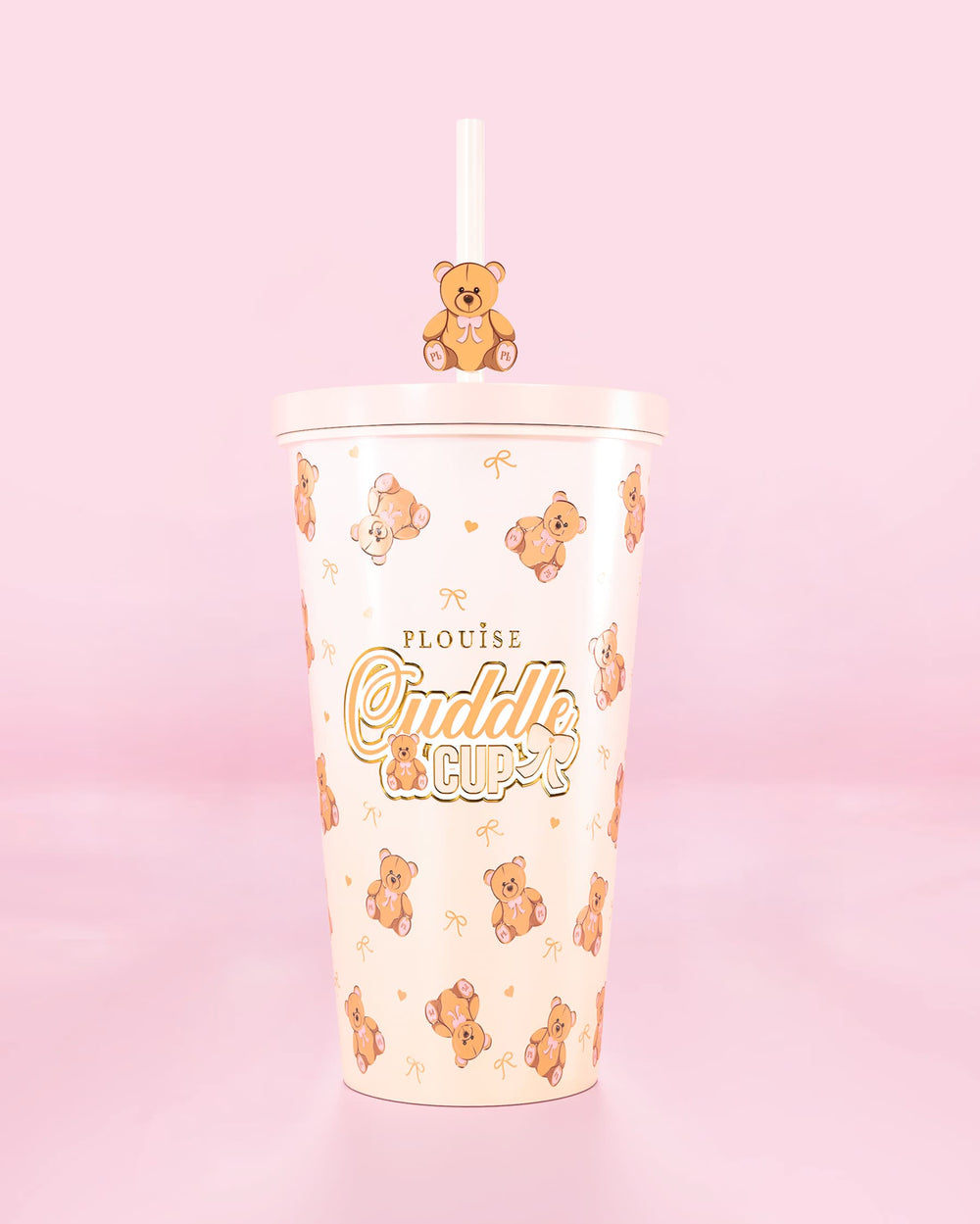 Stålglasmugg med sugrör och en nallebjörnsdesign med "Cuddle Cup"-text på en rosa bakgrund