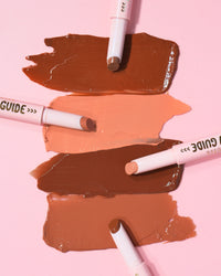 Swatches av P.Louise Glow Guide Glossy Lipstick Balms på en rosa bakgrund