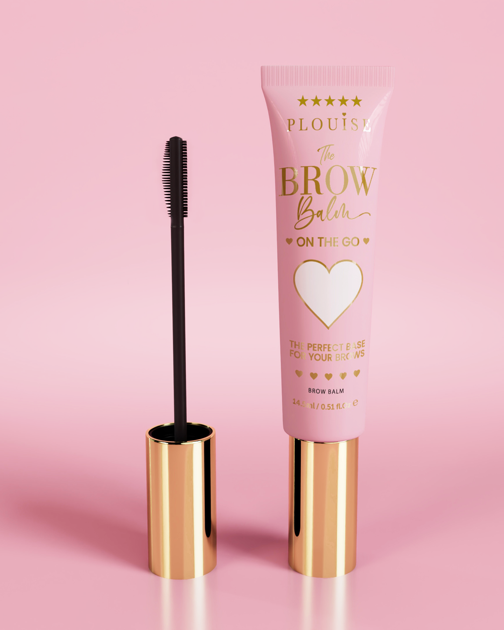 P.Louise Fluffy Soap Brow Balm Instant Fix-produkt i en rosa tub med ett gyllene lock, tillsammans med en svart ögonbrynsborste, utställd mot en rosa bakgrund.