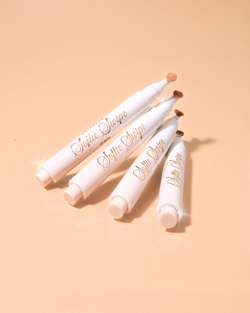 En bild av fyra P.Louise Softie Swipe Tinted Lip Masks i doft av kokosnötskaka staplade mot varandra med en beige bakgrund