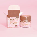 P. Louise "What's the Scoop?" stretchig kroppsskrubb i värmedoft med en värmegivande designförpackning på en rosa bakgrund