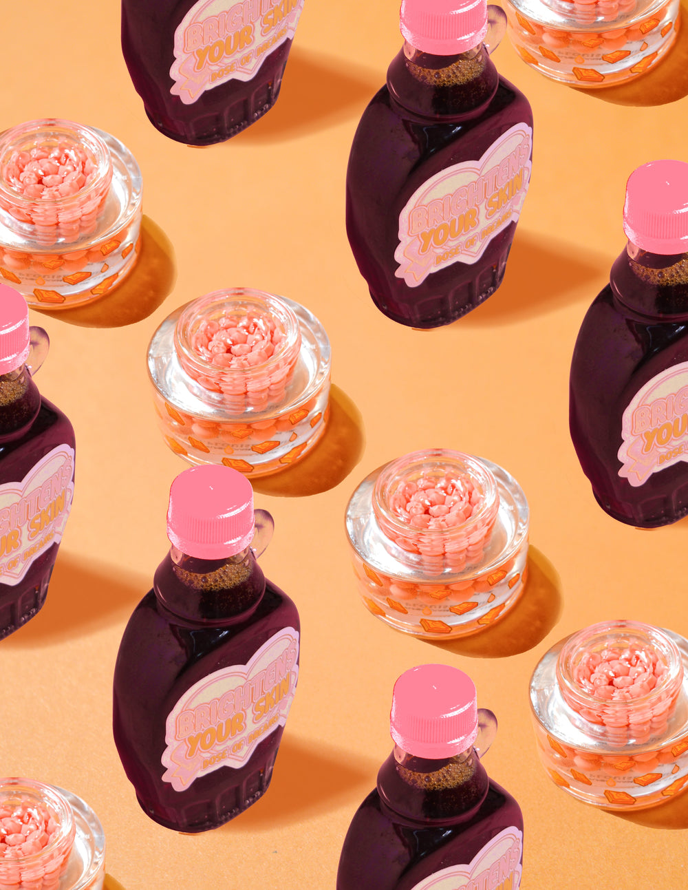 Klara behållare med P.Louise Dose of Dreams Vitamin C Capsule Cream med orange kapslar inuti dem omgivna av lila och rosa sirapsflaskor på en orange bakgrund