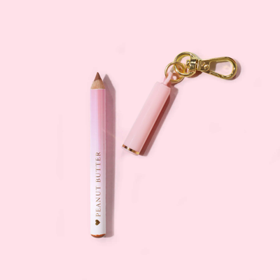 Rosa P.Louise mini-nyckelring lip liner med "Peanut Butter"-märke på en ljusrosa bakgrund