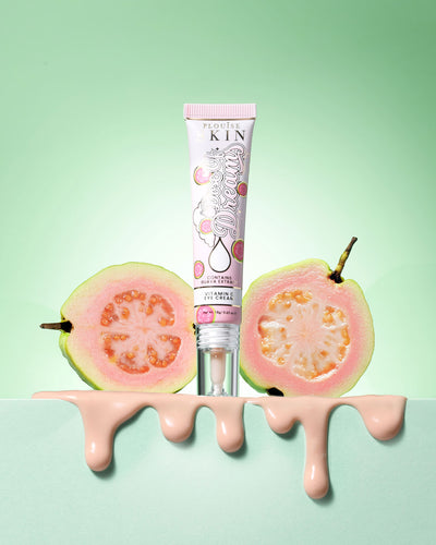 Tube of P.Louise Dose Of Dreams Vitamin C Brightening Eye Cream omgiven av guavafrukt på en grön bakgrund