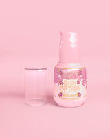 Rosa flaska P. Louise Erase The Trace Dark Spot Correcting Serum med locket av på en rosa bakgrund