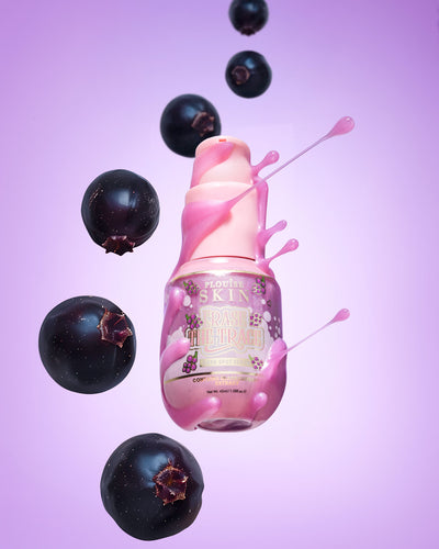 Rosa flaska P. Louise Erase The Trace Dark Spot Correcting Serum med vätska som kommer från flaskan omgiven av svarta vinbär på en lila bakgrund