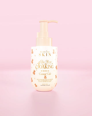 Flaska med P.Louise You Must Be Soaking badolja i kokosnötskaka mot en rosa bakgrund