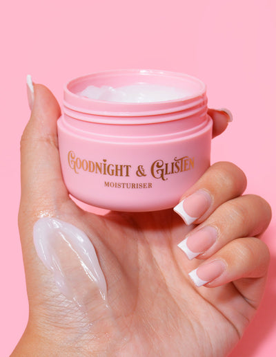En hand som håller i en rosa burk P.Louise Goodnight & Glisten Gel Moisturizer med lite fuktkräm synligt på .och
