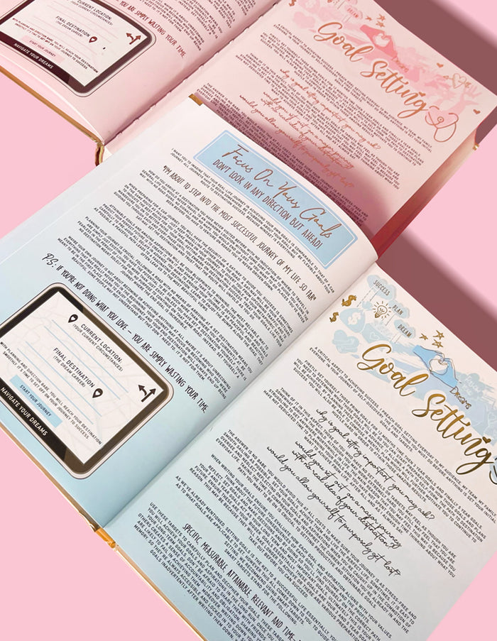 En inspirerande dagbok med flera synliga sidor, som visar avsnitt om målsättning och andra utvecklingsämnen, med rosa bakgrund.